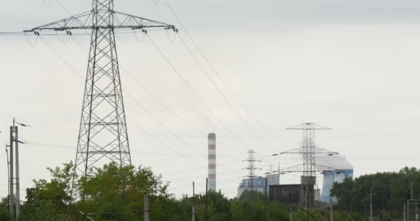 Rök från rören hög spänning torn trådar rör elektriska Station cement fabriken miljöförorening ekologi gröna träd grå himmel Polen Opole — Stockvideo