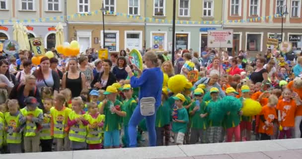 Педагог приймає відео Фото стоячи перед групою дітей діти стрибки мають задоволення педагогів батьків сімей на площі святкування — стокове відео