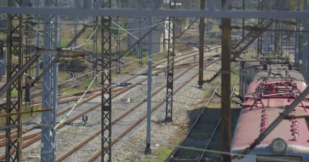 Gele locomotief is dat zijdelings trein verlaten is permanent trein dak Railroad Junction Railway Station draad torens kabels elektrische treinen zonnige dag — Stockvideo