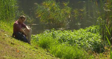 Gözlüklü Adam Göl Kıyısında Oturuyor Sırt Çantasından Kitabı Aldı Nature Fresh Green'de Sayfa Okuyucusu Aracılığıyla Kitap Okuma