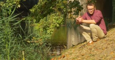 Adam Su Gölü Nehre Taş Atıyor Adam Banka Man Walks Away Yeşil Sazlık Oturuyor Rüzgar Güneşli Günü Güz Kuru Yapraklar Sallanan olduğunu