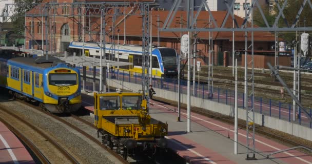 Locomotive jaune se déplace approchant Les trains de conducteurs sont des wagons debout Gare ferroviaire Jonction ferroviaire Feux de circulation ferroviaire Tours de fil — Video