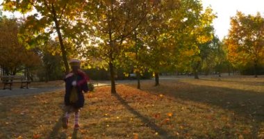 Bere ve Ceket Adil Örgü Kız ile Little Girl Sunset Rays Kız Park Girl Siluet tarafından Kaçan Ağaçtan Yaprak Aldı