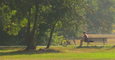 Adam Laptop Freelancer yazılımcı metin yazarı Tasarımcısı muhasebeci çalışan dizüstü bilgisayar ile Park ile O'nun bacaklar gergin aldı içinde bankta oturuyor
