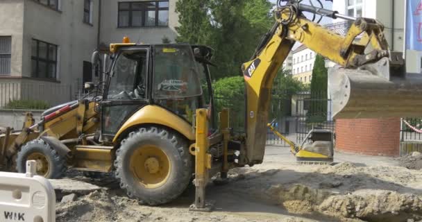 Graven en aarding van de trog door graafmachine op het segment Street — Stockvideo