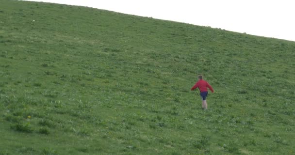 Chłopcy gry w piłkę nożną na zielone wzgórze — Wideo stockowe