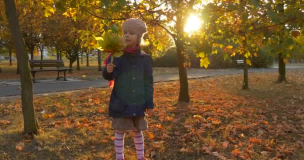 Petite fille blonde en béret Foulard rouge et veste tient le bouquet fait de feuilles et de fleurs et se balançant avec le bouquet Parler Marcher loin — Video