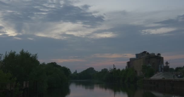 Budovy na molo, obloha s Cirrus a Cumulus šedé mraky, jezero se stromy po stranách — Stock video