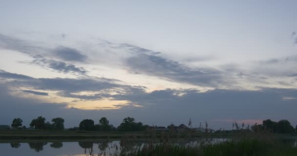 Cirrus šedé mraky na modré večerní obloze, louky, jezera — Stock video