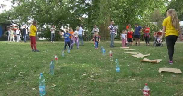 Garçon fille jouer le jeu fonctionne autour de la bouteille sur l'herbe, journée d'été ensoleillée — Video