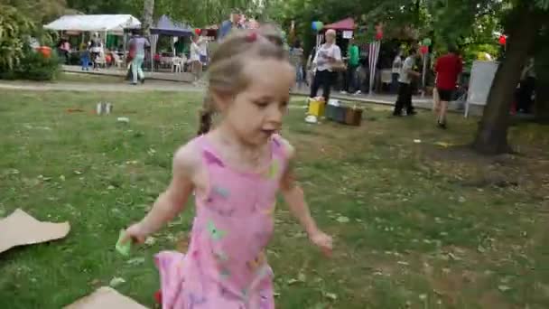 Chica correr jugar alrededor del papel en la hierba — Vídeos de Stock