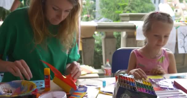 Papier speelgoed meisjes verf Foto's op papier met animators buiten in tent — Stockvideo