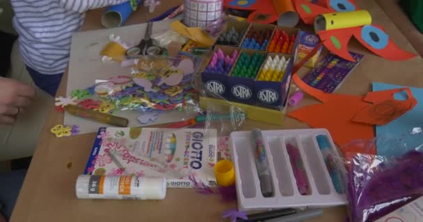 Papper leksaker flickor måla bilder på papper med animatörer utomhus i tält — Stockvideo