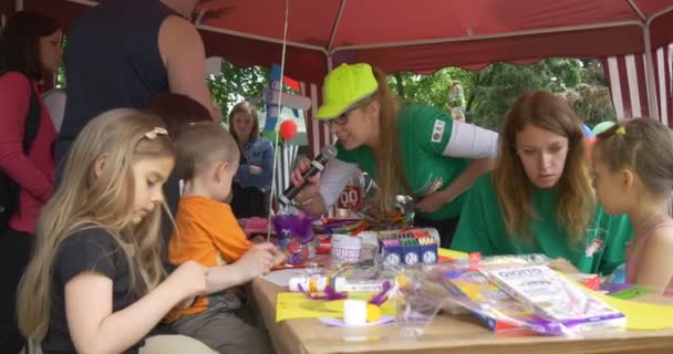 Filles avec des animateurs de plein air dans la tente filles Peindre des photos sur papier adultes aider — Video