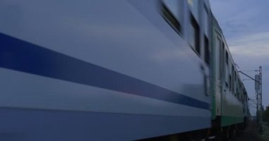 Yolcu treni hareket demiryolu parça Görünümü Kapat demiryolu kişi üzerinde ağ yeşil ağaçlar ve Binalar üzerinde arka plan Twilight bulutlu gökyüzü