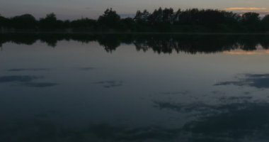 Nehir, ağaçlar ve gökyüzü yansıma su siluetleri on Sunset