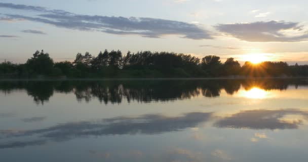 Coucher de soleil sur la rivière, silhouettes d'arbres et reflet du ciel dans l'eau — Video