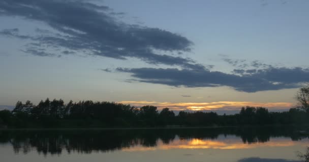 Coucher de soleil sur la rivière, silhouettes d'arbres et reflet du ciel dans l'eau — Video