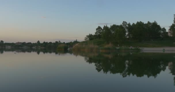 Puesta de sol en el río, siluetas de árboles y reflejo del cielo en el agua — Vídeos de Stock