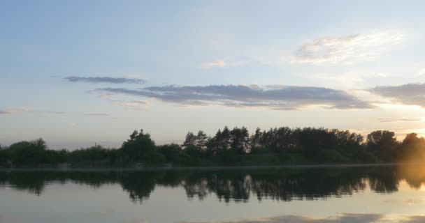 Pôr do sol no rio, silhuetas de árvores e reflexo do céu na água — Vídeo de Stock