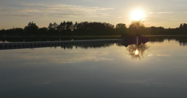 Solnedgång på floden, silhuetter av träd och himmel reflektion i vatten — Stockvideo