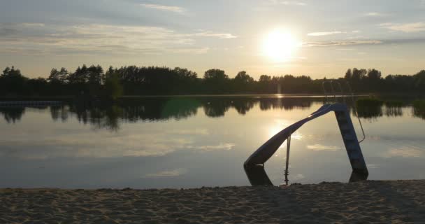 池塘， 河， 沙滩湖， 平滑水， 树木剪影的反射， 儿童丘特， 日落 — 图库视频影像
