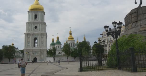 Sofia Square, Bell Tower of Sophia Cathedral, Zoom, Aproximando-se da Torre, Antiga Casa Multi-Storeyed no fundo, As pessoas estão caminhando pela Praça — Vídeo de Stock