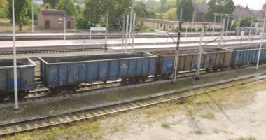 İnsanların yürüme platformu tarafından uzaktan yük treni istasyonu lokomotif vagonlar demiryolu bina demiryolu kavşak istasyonu yaprakları için geldi