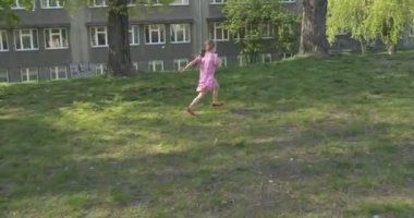 Yeşil taşma payı üzerinde kırmızı ayakkabı pembe elbiseli bebek kız kamera ishal için