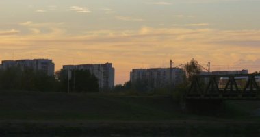Hareketli köprü doğru şehir yoluyla River Twilights günbatımı mavi gökyüzü pembe bulutlar tarafından nehir banka binaları ters banka trende olduğunu