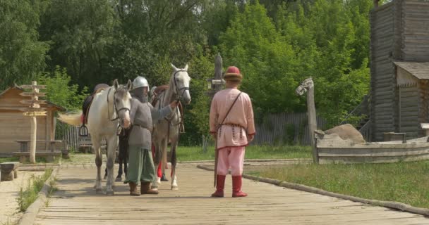 Tři herci jako princ Vladimir Velikého, Baptiser z Ruska a dva jeho bojovníci stojí, mluvení, namontujte na koně, zbavit — Stock video