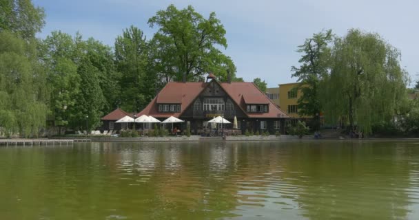 Huis aan de oever van het meer, parasols, houten pier — Stockvideo