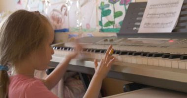 Piano elektronik klavye coşku ile oynayan bebek kız
