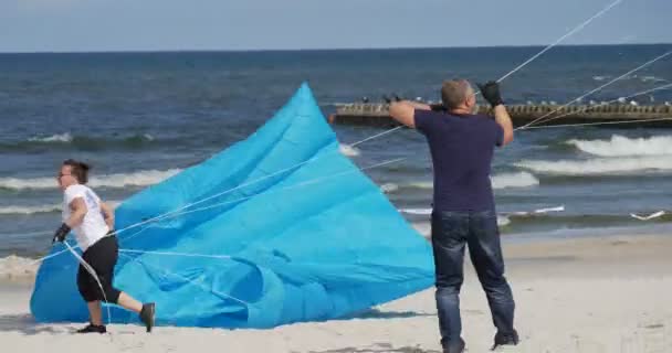 Persone che cercano di catturare il vento Persone che preparano i loro aquiloni e nuotatori d'aria o li volano sul festival internazionale degli aquiloni a Leba, Polonia . — Video Stock