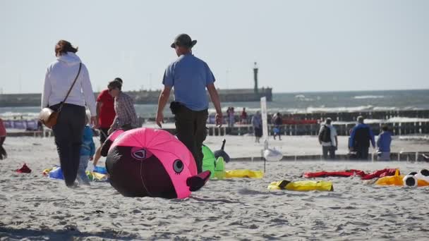 不同空气游泳躺在沙上莱，波兰的国际风筝节准备他们的风筝和空气游泳的人. — 图库视频影像