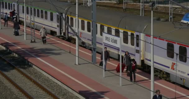 Ludzie z walizki na kółkach są pośpiech dostaje się pasażer pociągu wagonów kolejowe kolejowych stacji kolejowe Junction kolejowe światłach — Wideo stockowe