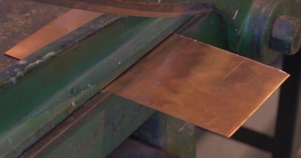 As mãos do homem estão instalando a pequena placa de cobre na guilhotina cortando a parte quadrada da placa de cobre na guilhotina Prepare-se para gravar artesanato — Vídeo de Stock