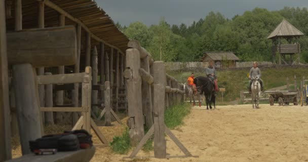 Tři jezdci na koních se vrací po písčitém poli směrem k kameře, stabilní, deštivé obloze, muži třesoucí se rukama — Stock video