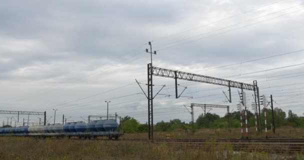 Tanques azules y grises del tren de carga se paran en la vía férrea Ferrocarril Contacto Red Lámpara Puestos Semáforos Cielo gris Lluvia Opole Polonia — Vídeos de Stock