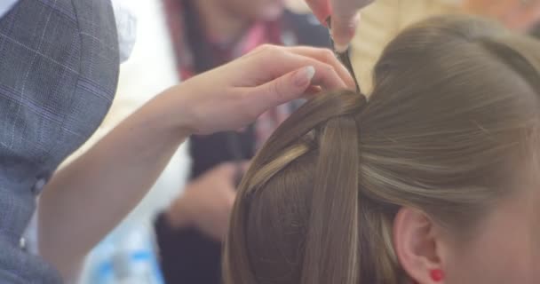 Peluquería estilista está fijando los mechones de pelo en la parte posterior de la cabeza con Bobby Pin y el modelo de aerosol de fijación de peluquería con pendientes rojos Peluquería de salón de belleza — Vídeos de Stock