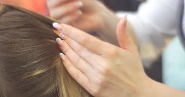Stylistní kadeřník je nakonec upevňování vlasů kadeřnictví vlasová vlákna na zadní část ženské hlavy modelu s dlouhými vlasy kadeřnictví