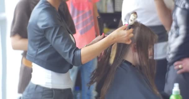美发师发型师坚持钳与燃烧卫生棉条使火剪头发股为妇女与长毛理发店美容美发 — 图库视频影像