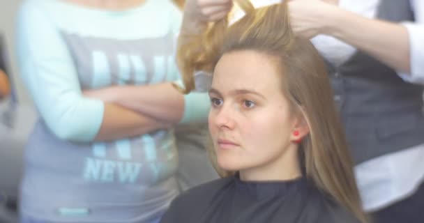 Frisör stylist är separera The hårstrå och fastställa det på toppen av huvudet med Bobby Pin att göra The frisyr lockar av locktänger för en kvinna med lång brun hår Barbershop frisörverksamhet Salon skönhetssalong — Stockvideo