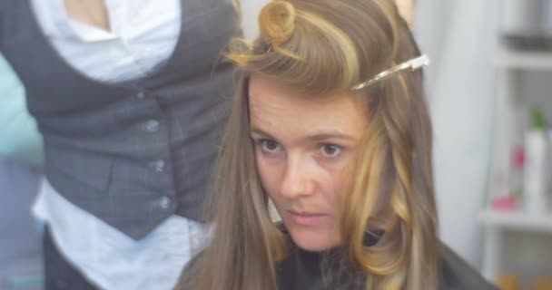 Stylist parrucchiere sta facendo i riccioli acconciatura sulla parte superiore della testa della donna con capelli lunghi fissaggio con parrucchiere Barrette Salone di bellezza — Video Stock