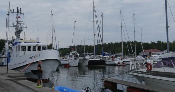 ヨットの病床にある桟橋に少年 Unties ボート ヨット クラブ ポート セーフハーバー穏やかな水夏曇りウエバ ポーランド — ストック動画