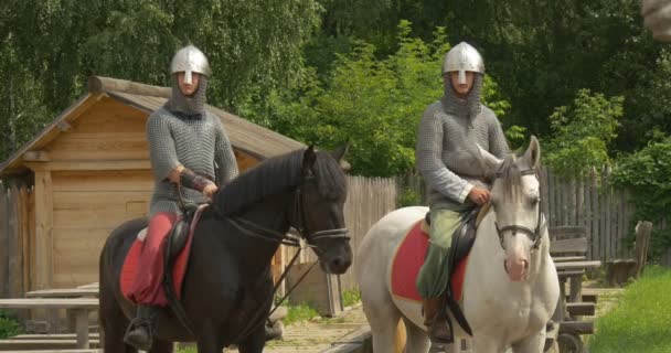 Twee acteurs, ruiters, ridders, bruine en witte paarden in ketting armors en helmen, Mid shot — Stockvideo