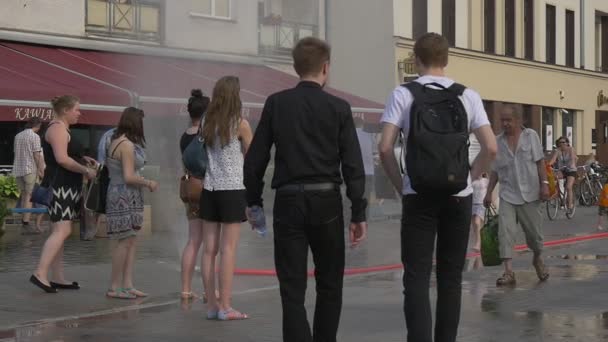 Sommige meisjes en jongens staan in de buurt van Cafe "Kawiarnia" — Stockvideo