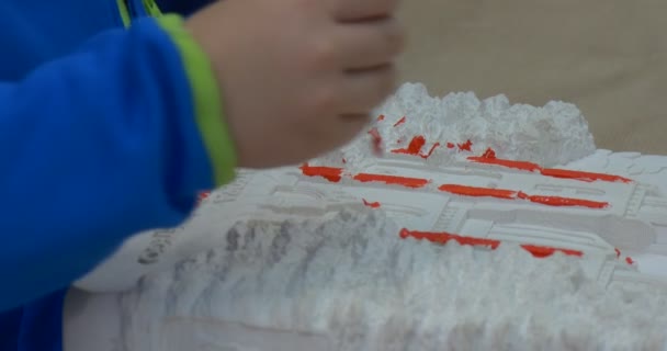 El niño está pintando las manos con el pincel Close Up Pintura Líneas Naranjas Creación de productos hechos a mano para la subasta de caridad — Vídeo de stock