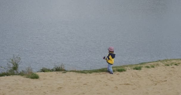 Παιδί μικρό κορίτσι στέκεται ρίχνοντας την άμμο στον παππού του ποταμού πλησιάζει και να οδηγήσει το κορίτσι μακριά οικογένεια στο ποτάμι Man και παιδί εγγονή — Αρχείο Βίντεο