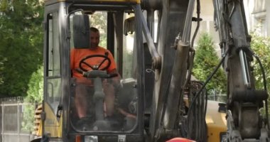 Workers in Workwear Driver in Excavator Cabin Scoop Close Up Men are Raving the Road Road Repair Excavator is Leaving People on the Street Blocks